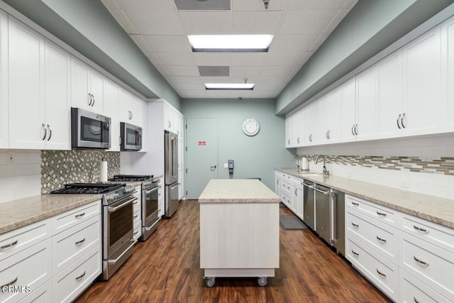 kitchen featuring a center island, dark hardwood / wood-style floors, light stone counters, and high end appliances