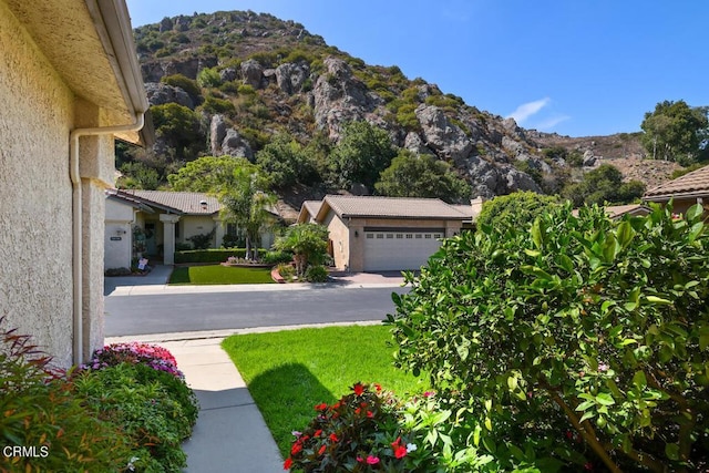 view of yard with a mountain view and a garage