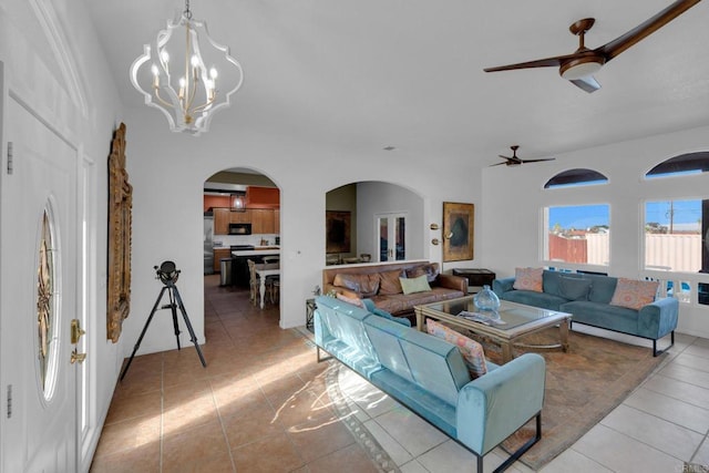 tiled living room featuring ceiling fan with notable chandelier