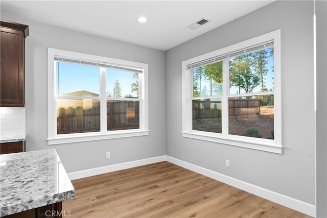 unfurnished dining area with light wood-type flooring and a wealth of natural light