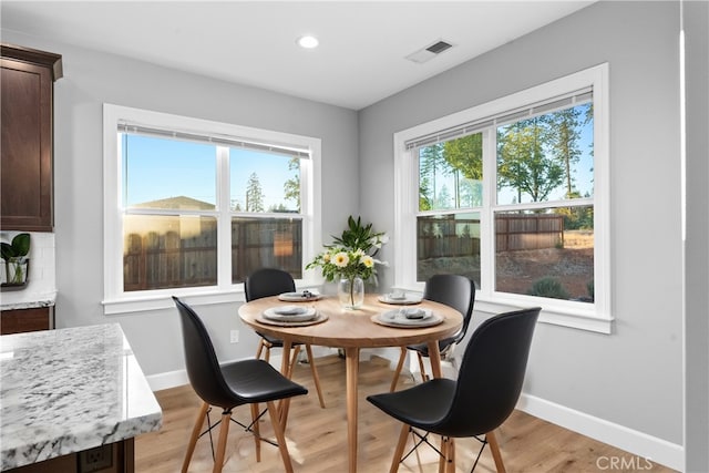 dining space with light hardwood / wood-style floors and a wealth of natural light