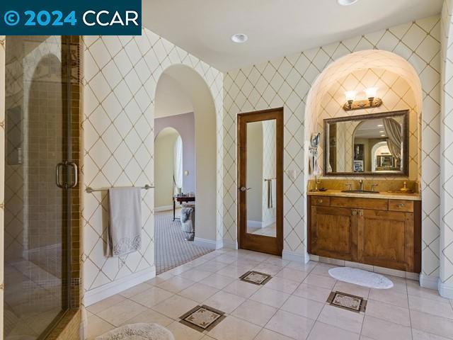 bathroom featuring tile patterned flooring, vanity, and an enclosed shower