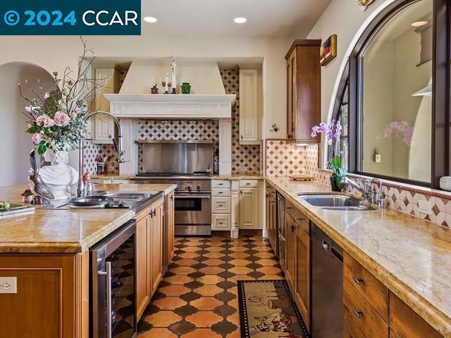 kitchen featuring dishwasher, tasteful backsplash, wine cooler, and sink