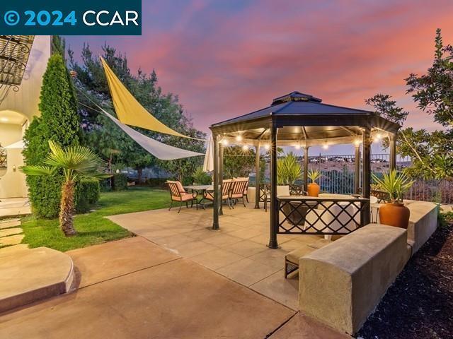 patio terrace at dusk with a gazebo and an outdoor hangout area