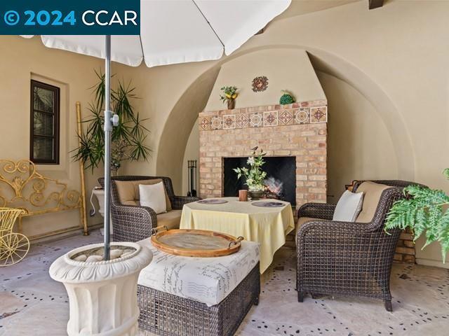 living area featuring carpet flooring and an outdoor brick fireplace