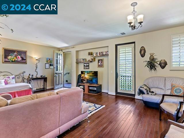 living room with dark hardwood / wood-style flooring and an inviting chandelier