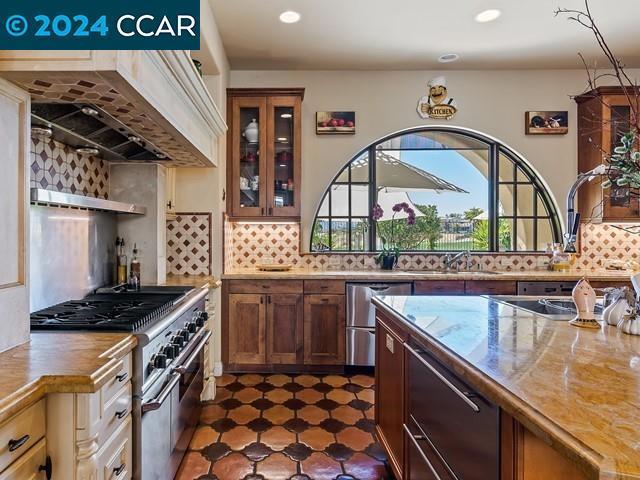 kitchen with premium range hood, backsplash, sink, and appliances with stainless steel finishes