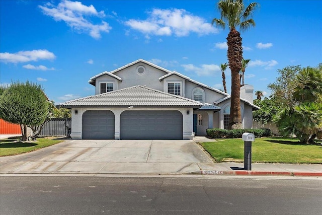 mediterranean / spanish home featuring a front lawn and a garage