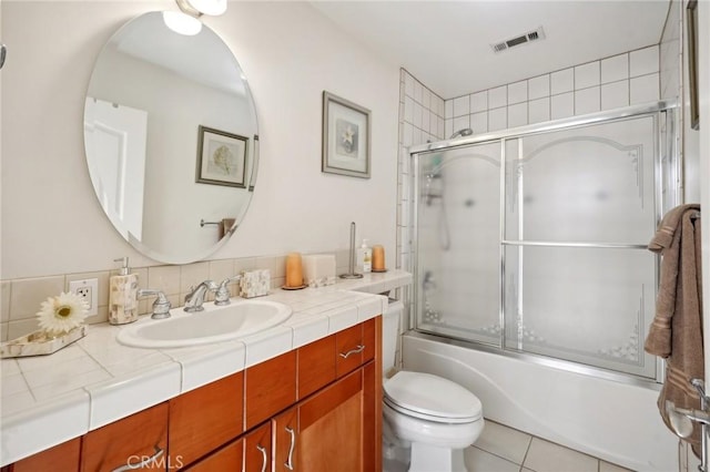 full bathroom with tile patterned floors, vanity, toilet, and combined bath / shower with glass door