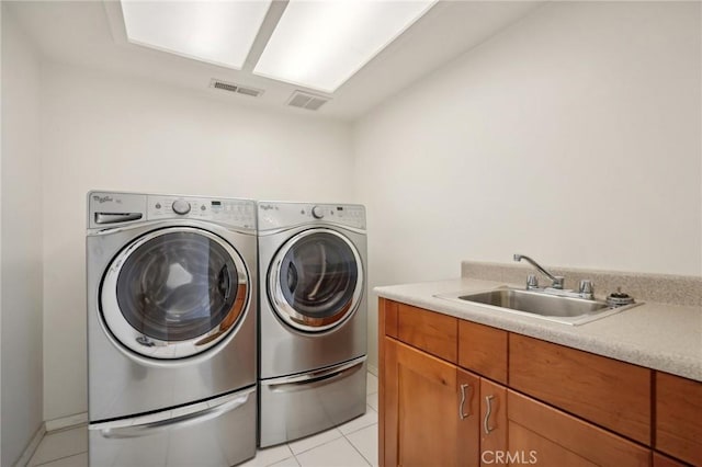 laundry room with washer and dryer, sink, light tile patterned floors, and cabinets