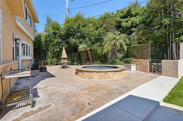 view of patio / terrace with an in ground hot tub