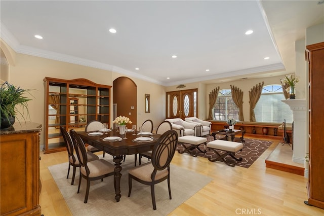 dining space with crown molding and light hardwood / wood-style flooring