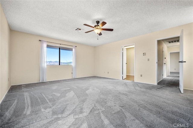 empty room with ceiling fan, carpet floors, and a textured ceiling