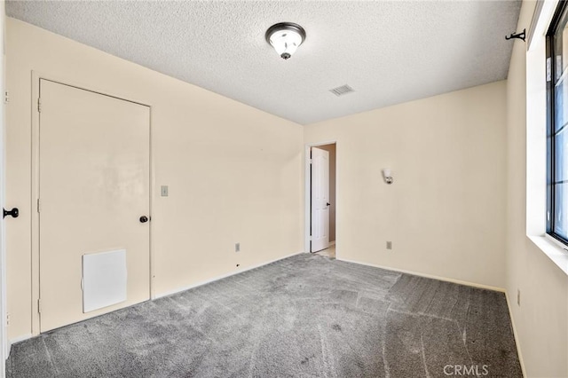 carpeted spare room featuring a textured ceiling