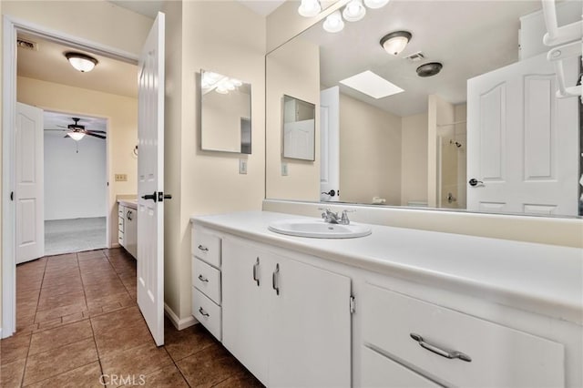 bathroom with a shower, ceiling fan, tile patterned flooring, and vanity