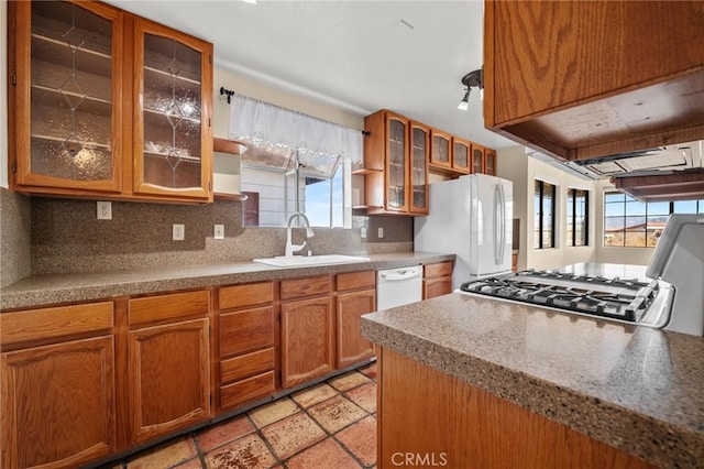 kitchen featuring decorative backsplash, white appliances, sink, and a wealth of natural light