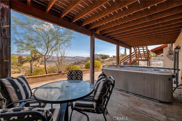 view of patio with a mountain view and a hot tub