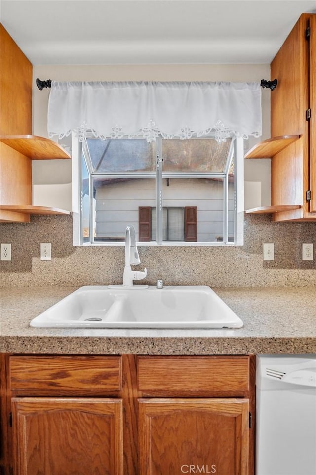 kitchen with dishwasher, decorative backsplash, and sink