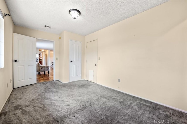 empty room with carpet flooring and a textured ceiling