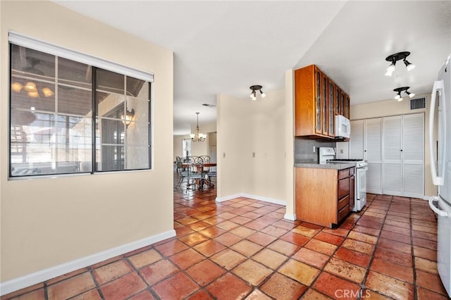 kitchen featuring white appliances and an inviting chandelier