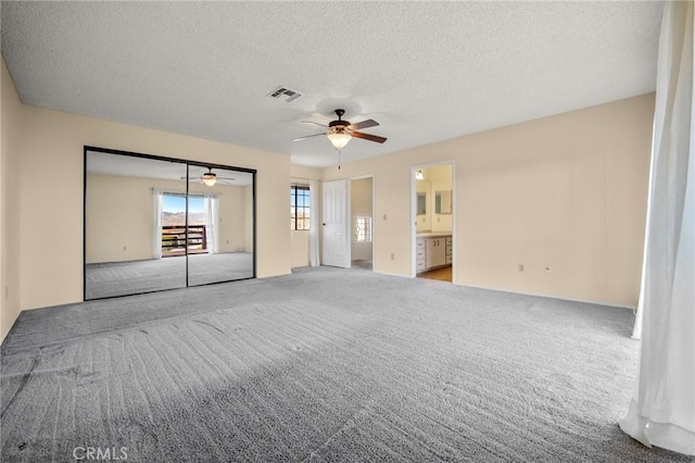 carpeted spare room featuring ceiling fan and a textured ceiling