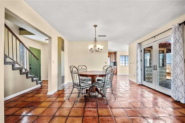 tiled dining area with french doors and an inviting chandelier