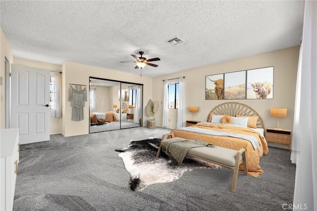 bedroom featuring carpet, a textured ceiling, a closet, and ceiling fan