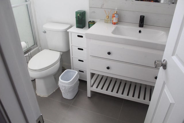 bathroom featuring toilet, tile patterned flooring, vanity, and walk in shower