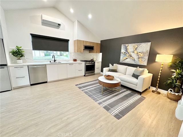 living room with high vaulted ceiling, light hardwood / wood-style floors, an AC wall unit, and sink