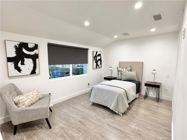 bedroom featuring lofted ceiling and light hardwood / wood-style floors