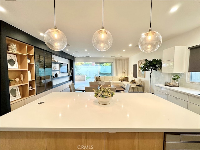 kitchen featuring hanging light fixtures, a large island, white cabinets, and tasteful backsplash