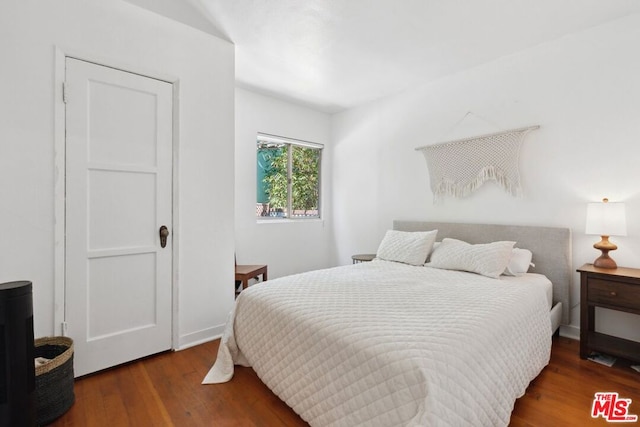 bedroom with dark hardwood / wood-style flooring