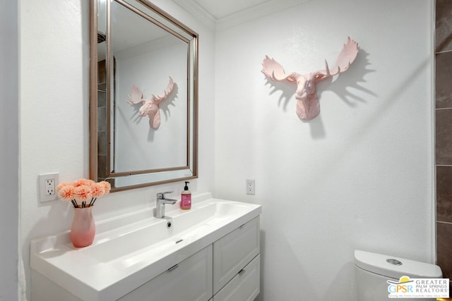 bathroom featuring ornamental molding, toilet, and vanity