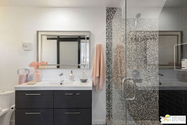 bathroom with vanity, a shower with shower door, and toilet