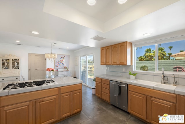 kitchen featuring sink, dishwasher, white gas stovetop, decorative light fixtures, and tile countertops