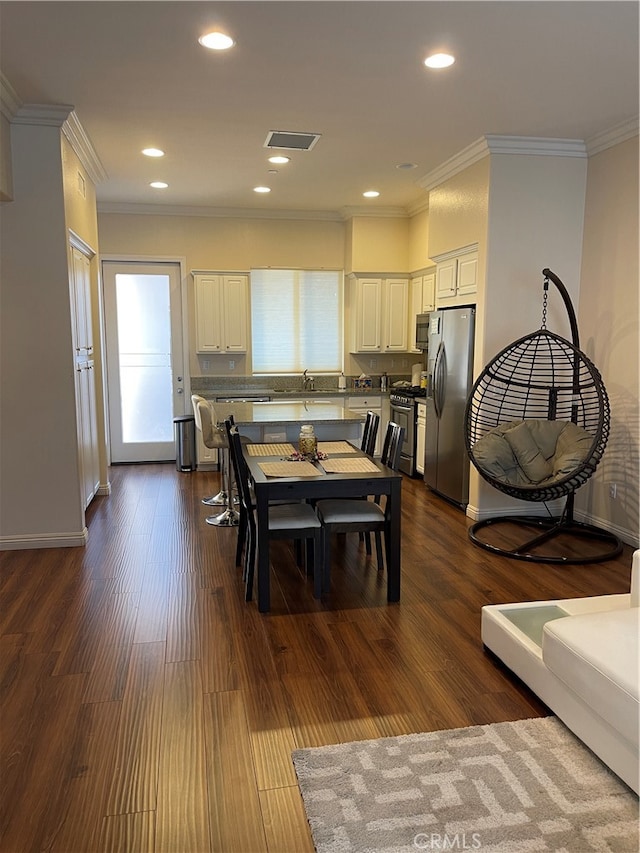 dining area with ornamental molding, dark hardwood / wood-style flooring, and plenty of natural light