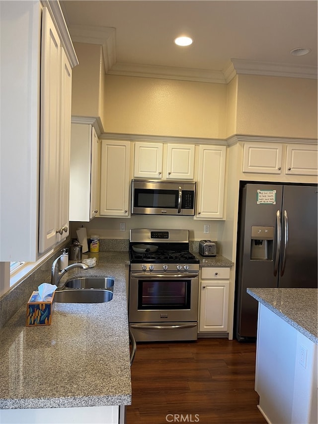 kitchen with dark hardwood / wood-style flooring, stainless steel appliances, white cabinetry, and sink