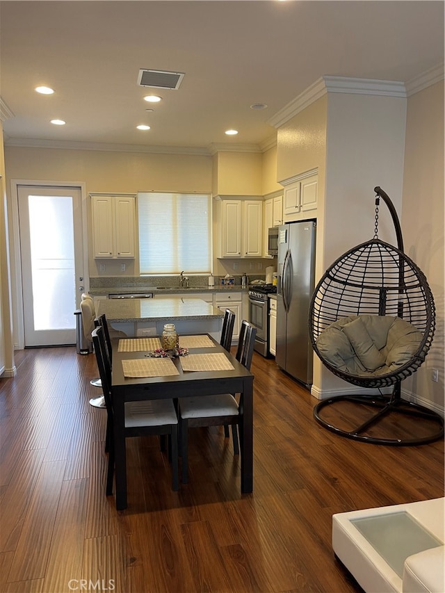 dining space featuring ornamental molding, dark hardwood / wood-style flooring, and a wealth of natural light