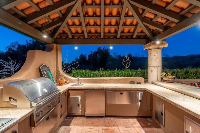 view of patio with a gazebo, exterior kitchen, sink, and grilling area