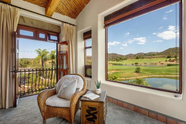 sunroom with a water and mountain view, wood ceiling, and vaulted ceiling with beams