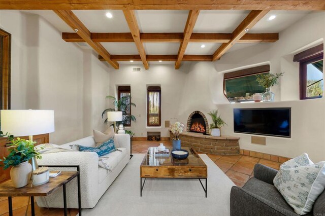 tiled living room with a brick fireplace, beamed ceiling, and coffered ceiling