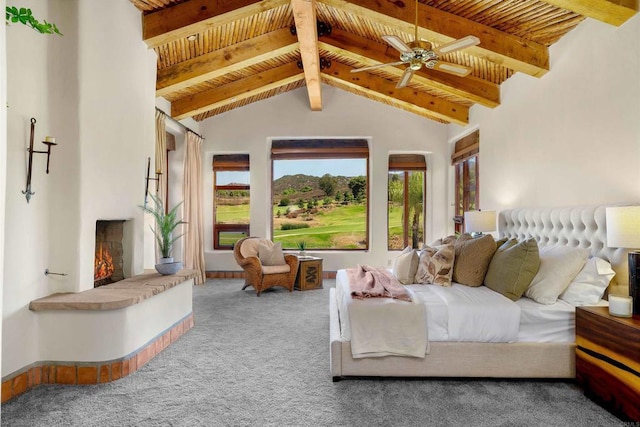 bedroom featuring ceiling fan, vaulted ceiling with beams, wood ceiling, and carpet flooring