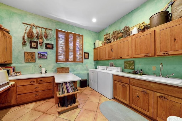 laundry room with washer and dryer, sink, light tile patterned floors, and cabinets