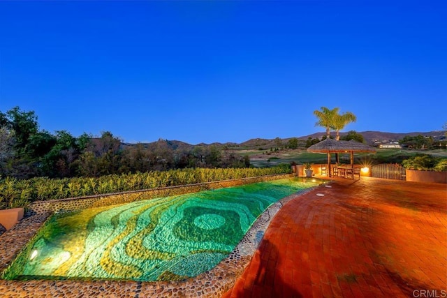 view of swimming pool with a mountain view and a gazebo