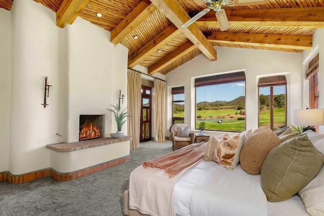 carpeted bedroom featuring vaulted ceiling with beams, a fireplace, and wooden ceiling