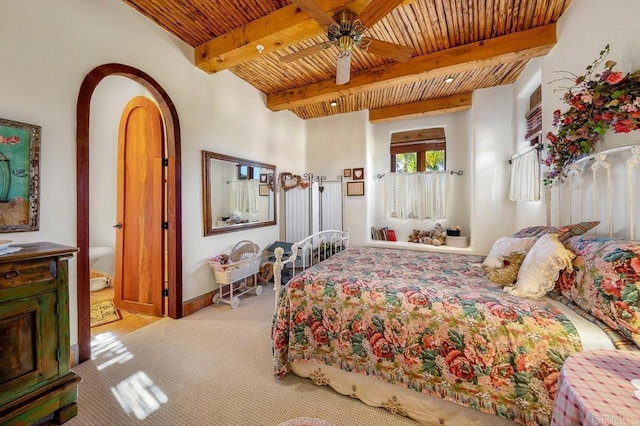 carpeted bedroom with ensuite bath, ceiling fan, wooden ceiling, and beamed ceiling