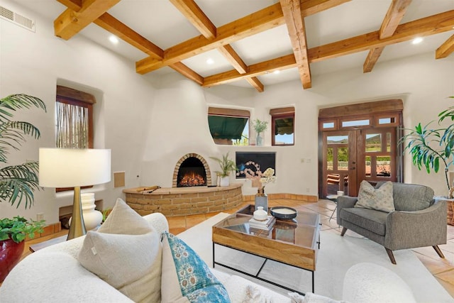 living room with light tile patterned floors, a brick fireplace, beamed ceiling, and coffered ceiling