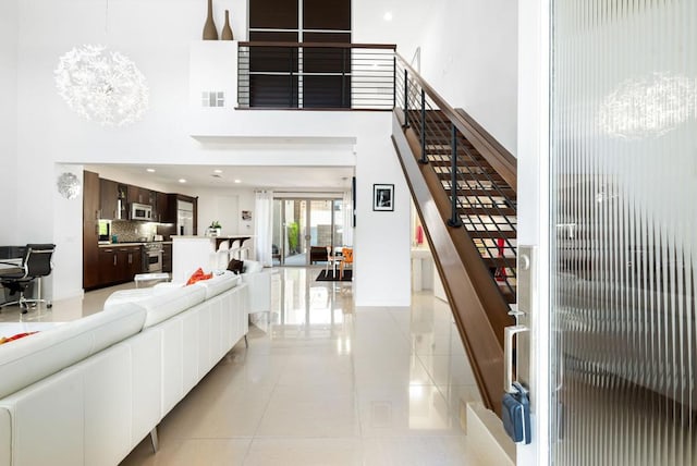 stairway with tile patterned floors and an inviting chandelier