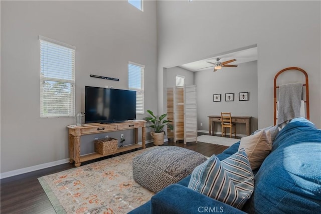 living room featuring ceiling fan, dark hardwood / wood-style flooring, and a high ceiling