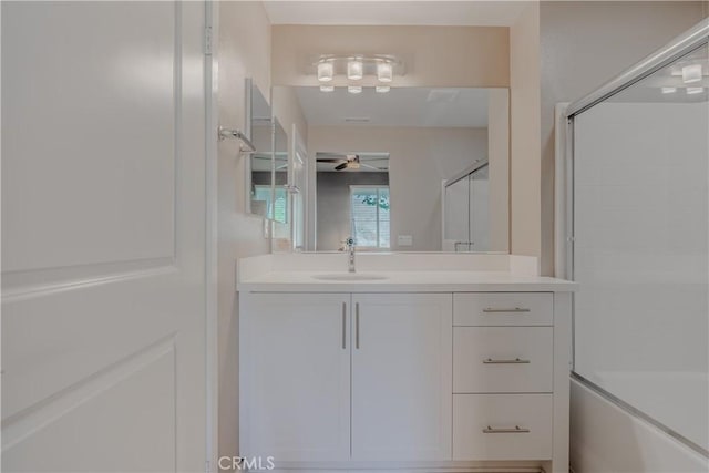 bathroom with shower / bath combination with glass door, ceiling fan, and vanity